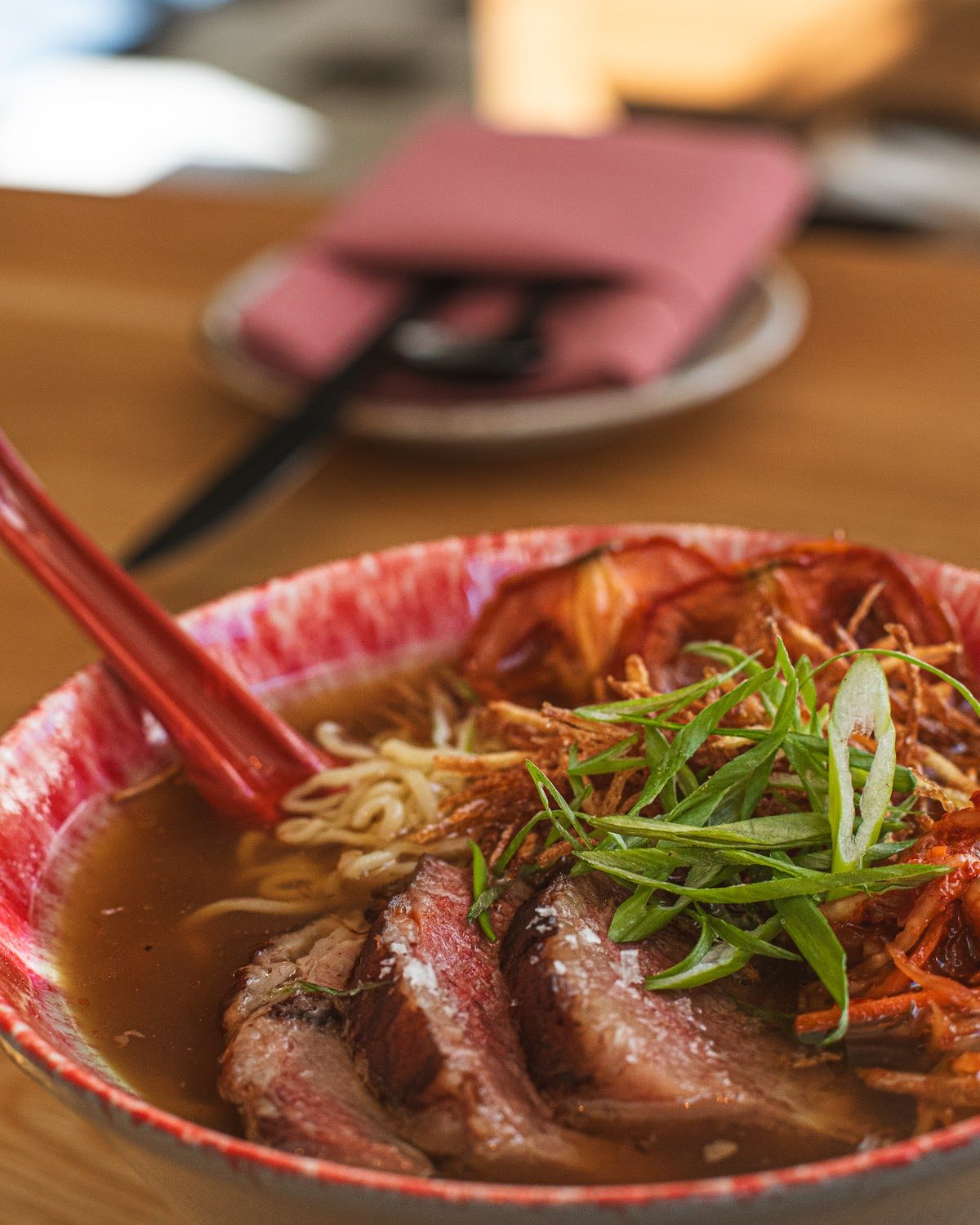 Ramen bowl with sliced beef, scallions and chili oil